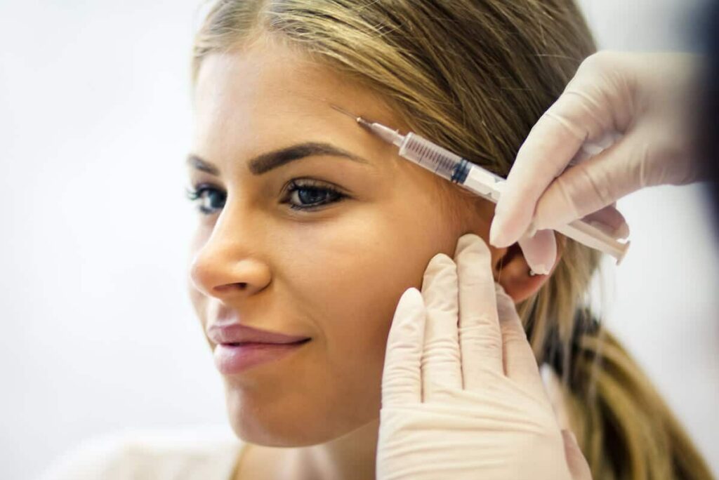 woman being injected in the face with Botox injectable anti-wrinkle treatment to reduce fine lines and wrinkles.