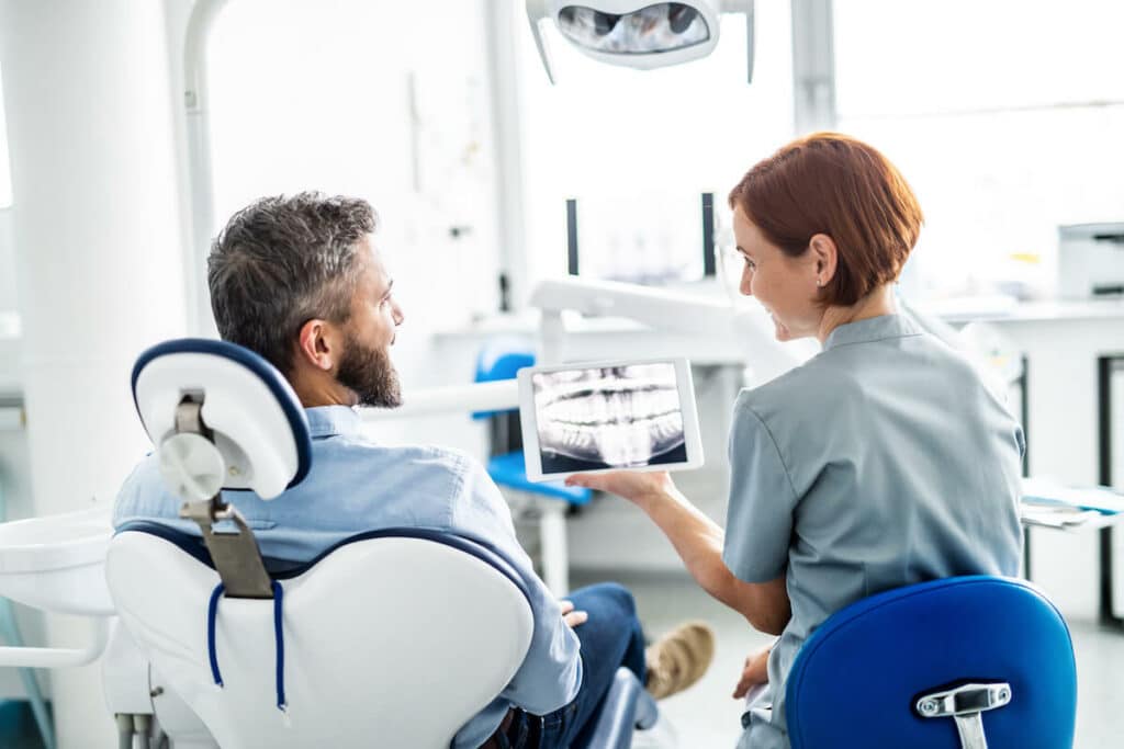 dentist explaining results of oral examination during a dental health checkup in dental surgery